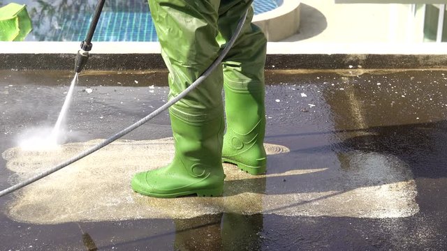 It&rsquo;s time for a good clean up  by professional cleaning services . Worker cleaning grunge terrace on second floor   with electrical high pressure washer machine splashing the dirt,4K time lapse .