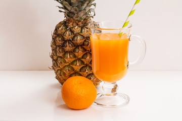 Fresh tropical fruits and glass of juice on white background.
