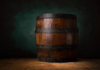 Beer barrel with beer glasses on a wooden table. The dark brown background.