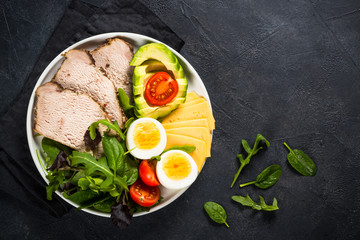 Keto diet plate on black stone table.