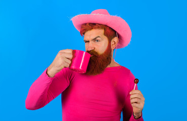 Cowboy with cup. American West. Western man with hat. Pink velvet cowboy hat. Gay. Portrait of...