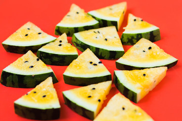 cut off triangular slices of ripe yellow watermelon on white background