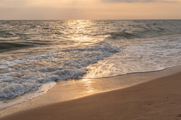 Sand beach with sunshine reflect in the morning at sunrise.