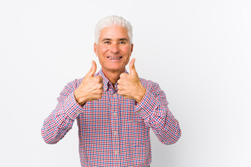 Senior caucasian man isolated with thumbs ups, cheers about something, support and respect concept.