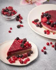 Raw vegan berry cherry cheesecake gluten-free on grey background.