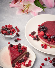 Raw vegan berry cherry cheesecake gluten-free on grey background.