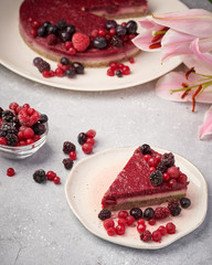Raw vegan berry cherry cheesecake gluten-free on grey background.