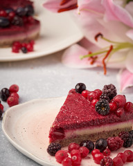 Raw vegan berry cherry cheesecake gluten-free on grey background.