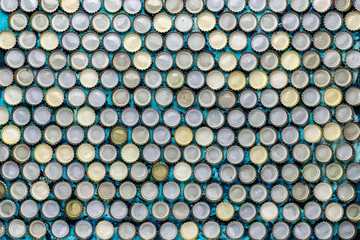 Background of beer lids laid out in a row top view