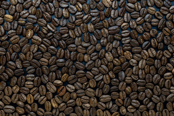 Roasted coffee beans on a black table top view