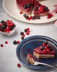Raw vegan berry cherry cheesecake gluten-free on grey background.