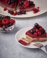 Raw vegan berry cherry cheesecake gluten-free on grey background.