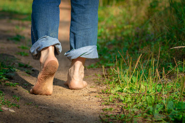 Man walking on footpath forest. Close-up of bare feet soiled with ground. healthy lifestyle. - Powered by Adobe