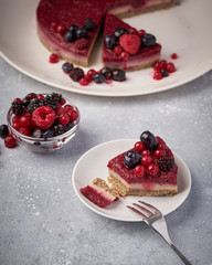 Raw vegan berry cherry cheesecake gluten-free on grey background.