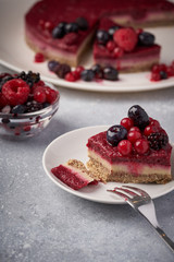Raw vegan berry cherry cheesecake gluten-free on grey background.