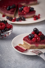 Raw vegan berry cherry cheesecake gluten-free on grey background.