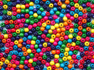 Multicolored wooden beads on a white wooden background, Can use as background or wallpaper.