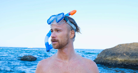 Young male swimmer with snorkling glasses dive in the summer sea	