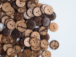 Wooden button on a wooden background, Buttons made from Coconut shell, Top view with copy space.