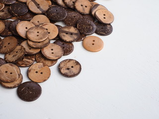Obraz premium Wooden button on a wooden background, Buttons made from Coconut shell, Top view with copy space.