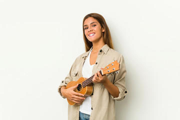 Young caucasian woman playing ukelele isolated