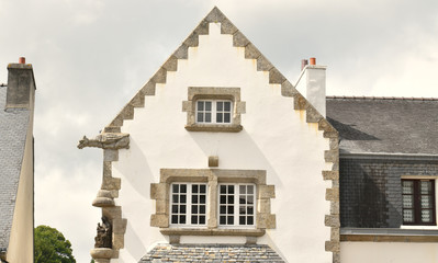 Fototapeta na wymiar En Bretagne une maison bretonne avec son architecture caractéristique et sa gargouille et ses fenêtres à meneaux