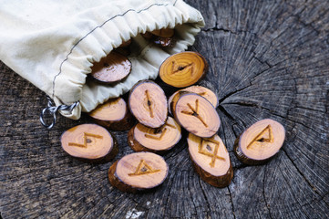 wooden runes in a bag on an old stump
