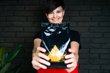 beautician hold ransparent packet of Seal Wax Beads. Bright colored granules. Wooden...