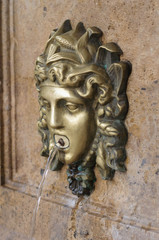 a small fountain in the form of the head of a Medusa Gorgon