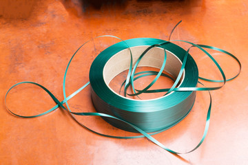 Green packing straps or tape on the floor. Polypropylene tape on the coil.