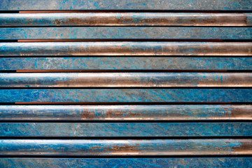 Blue empty rusty metal pipe wall, cracked paint, parallel. Background, texture