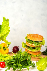Tasty burger with cutlet, cheese and letuce on wooden board.