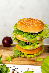 Tasty burger with cutlet, cheese and letuce on wooden board. Close-up.