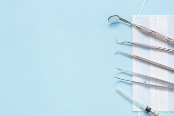 Set of Dentist's medical equipment tools. Stainless steel dental equipment on blue background with copy space.