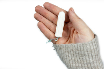 White clean tampon on woman's hand isolated on a white background. Menstruation time. Hygiene and protection.