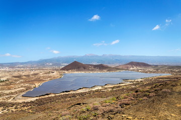 Solar panels at photovoltaics power station farm, future innovation energy concept, blue sky with...