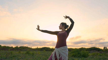 Happy female dance in the summer fields during beautiful sunset	