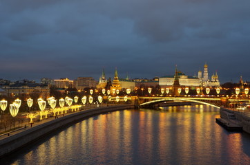 Fototapeta na wymiar Evening view of the Moscow Kremlin, the Big Stone bridge and Prechistenskaya embankment with festive illumination. Moscow, Russia