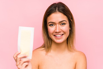 Young caucasian woman holding a depilatory band isolated happy, smiling and cheerful.