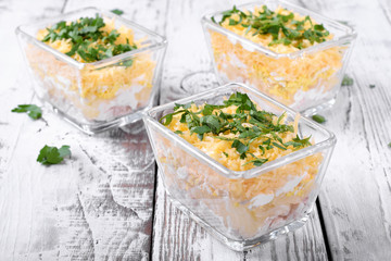 Layered salad with chicken, pineapple and cheese served in portion bowls