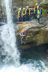 Faszination Canyoning beim gewagten Sprung in einen tosenden Wasserfall