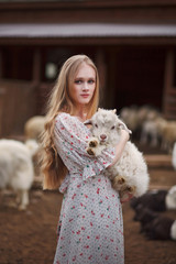girl in the arms of a lamb farm in the mountains