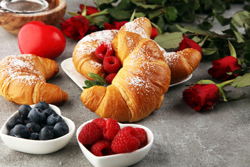 Delicious breakfast with fresh croissants and ripe berries and mint for valentines day