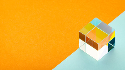 bright glass cube on an orange-blue background, empty space for text, minimalism, abstraction