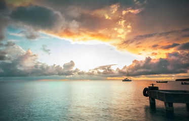 Panorama of beautiful sunset over ocean and sailboats