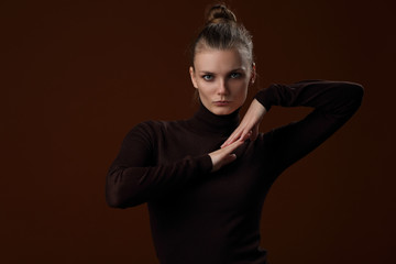 Beautiful girl in a maroon turtleneck on a brown background