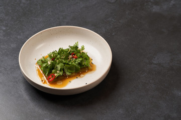 Smashed cucumbers plate with red chili pepper garlic parsley and vegetable oil.