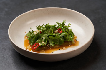 Smashed cucumbers plate with red chili pepper garlic parsley and vegetable oil.