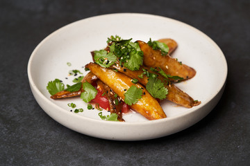 Sweet crispy eggplant or aubergine in white plate on dark table