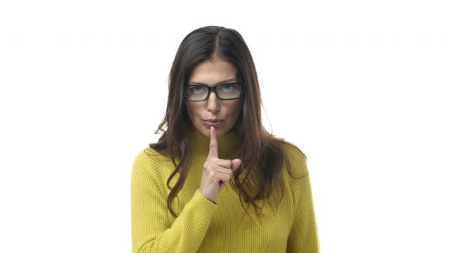 Slow-motion serious-looking strict and bossy female teacher in glasses, scolding for talking in class, shushing, tell be quiet, demand silence and good behaviour, standing white background